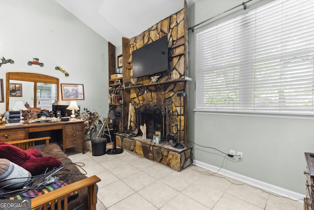214 Highland Dr, Warner Robins, GA 31088 - tiled living area with lofted ceiling, a stone fireplace, and baseboards
