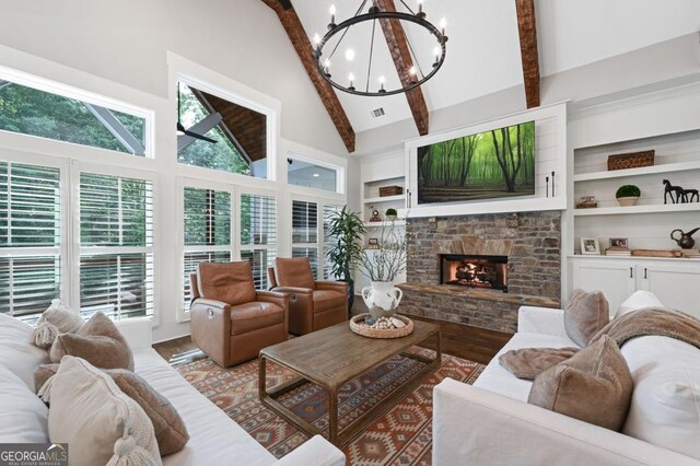 221 Goss Ln, Ball Ground, GA 30107 - living room featuring wood finished floors, a chandelier, high vaulted ceiling, beam ceiling, and a stone fireplace