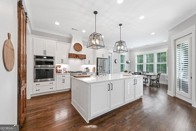 221 Goss Ln, Ball Ground, GA 30107 - kitchen featuring ornamental molding, light countertops, appliances with stainless steel finishes, tasteful backsplash, and white cabinetry