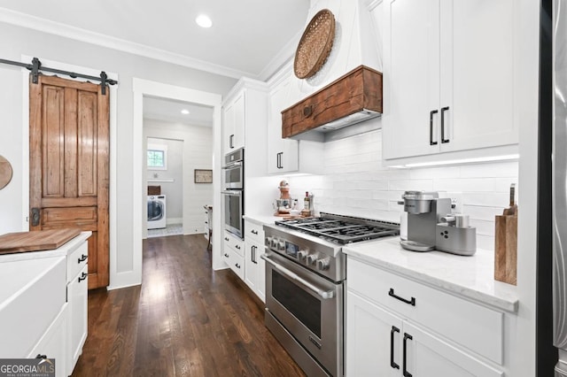 221 Goss Ln, Ball Ground, GA 30107 - kitchen with appliances with stainless steel finishes, washer / dryer, backsplash, white cabinets, and crown molding