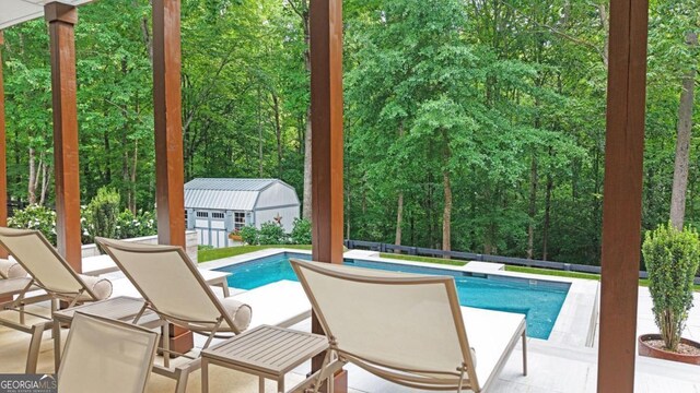 221 Goss Ln, Ball Ground, GA 30107 - outdoor pool featuring an outbuilding, a patio area, and a wooded view