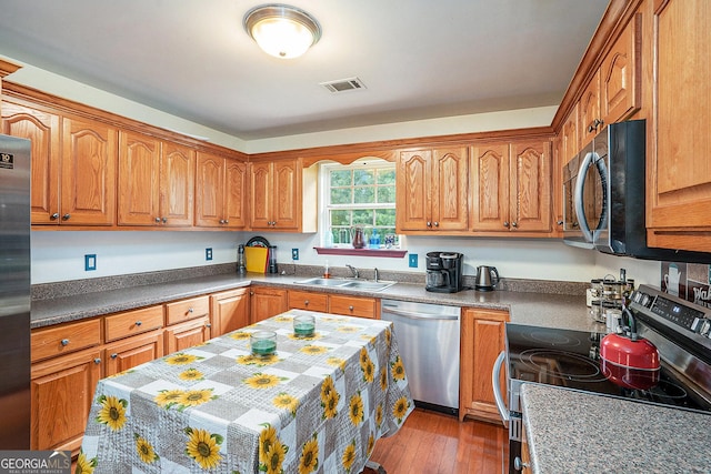 259 Hanover Cir SE, Calhoun, GA 30701 - kitchen with appliances with stainless steel finishes, wood finished floors, and brown cabinets