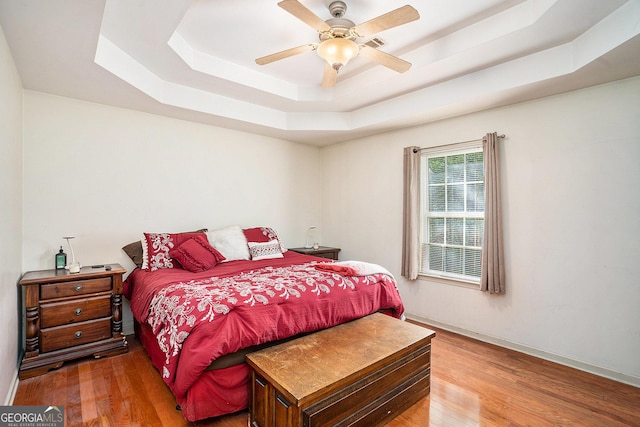 259 Hanover Cir SE, Calhoun, GA 30701 - bedroom with a raised ceiling, light wood-style flooring, and a ceiling fan