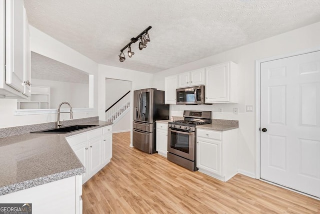 1186 Hawthorn Ln, Grayson, GA 30017 - kitchen featuring stainless steel appliances, a textured ceiling, light wood-type flooring, white cabinetry, and track lighting