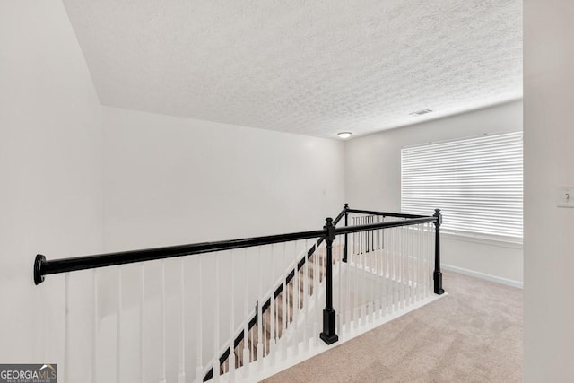 1186 Hawthorn Ln, Grayson, GA 30017 - hallway with an upstairs landing, carpet floors, and a textured ceiling