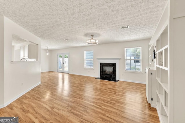 1186 Hawthorn Ln, Grayson, GA 30017 - unfurnished living room featuring light wood finished floors, a high end fireplace, and a textured ceiling