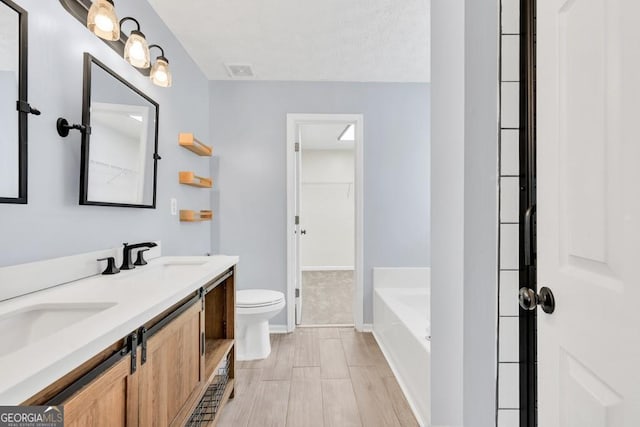 1186 Hawthorn Ln, Grayson, GA 30017 - bathroom with double vanity, a bath, wood finished floors, and a walk in closet