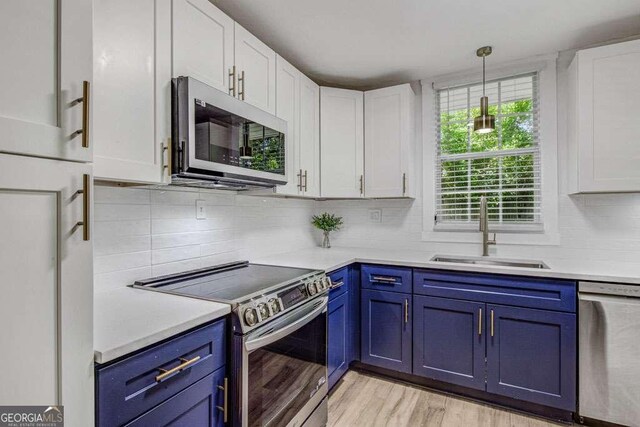 2572 Bates St SE, Smyrna, GA 30080 - kitchen featuring stainless steel appliances, a sink, blue cabinets, and white cabinetry