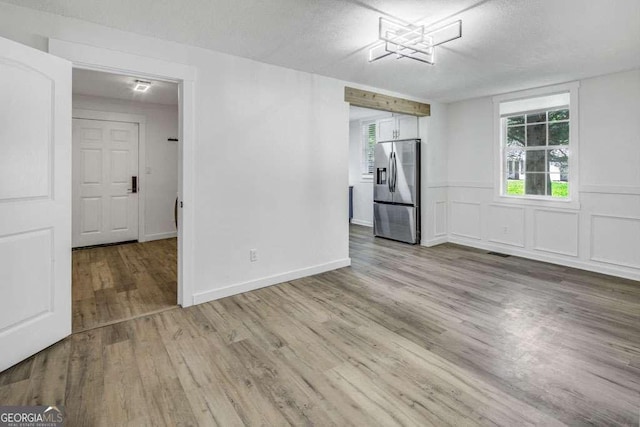 2572 Bates St SE, Smyrna, GA 30080 - spare room with wood finished floors, healthy amount of natural light, and a textured ceiling