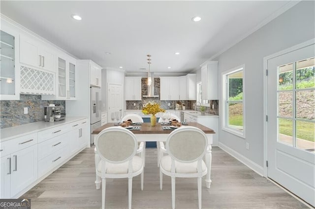 1226 Bloomsbury Ln, Gainesville, GA 30501 - kitchen with wall chimney exhaust hood, backsplash, white cabinets, glass insert cabinets, and a center island