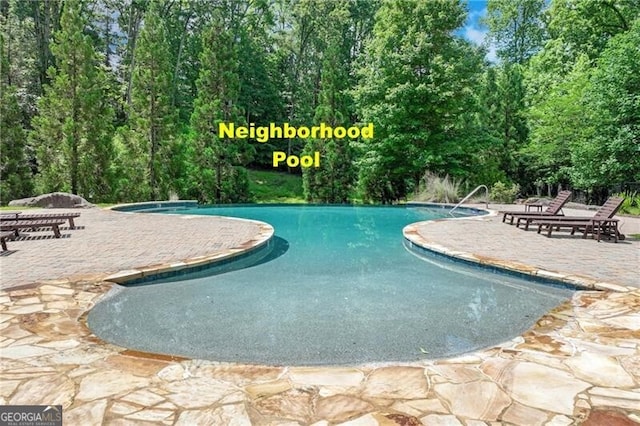 1226 Bloomsbury Ln, Gainesville, GA 30501 - swimming pool featuring a patio area and view of wooded area