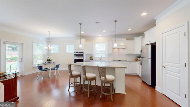 1391 Crooked Creek Rd, Greensboro, GA 30642 - kitchen with appliances with stainless steel finishes, dark wood-style flooring, a center island, light stone counters, and crown molding