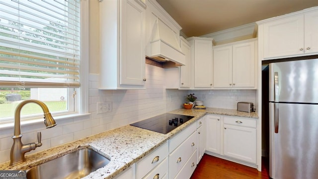 1391 Crooked Creek Rd, Greensboro, GA 30642 - kitchen with freestanding refrigerator, a sink, black electric stovetop, white cabinetry, and ornamental molding