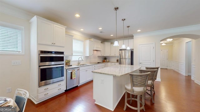 1391 Crooked Creek Rd, Greensboro, GA 30642 - kitchen with appliances with stainless steel finishes, a sink, arched walkways, a center island, and white cabinetry