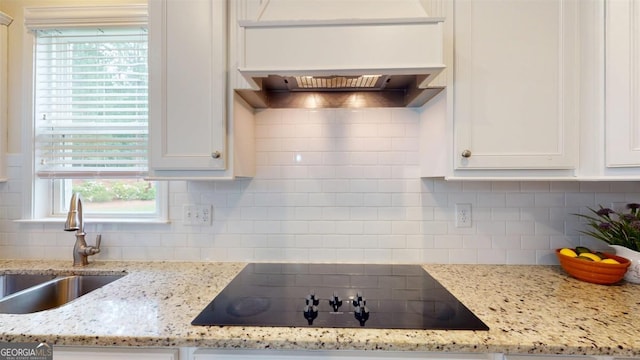 1391 Crooked Creek Rd, Greensboro, GA 30642 - kitchen featuring black electric cooktop, a sink, white cabinetry, and backsplash