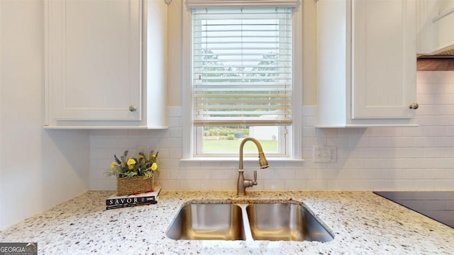 1391 Crooked Creek Rd, Greensboro, GA 30642 - kitchen with a sink, decorative backsplash, white cabinets, and light stone counters