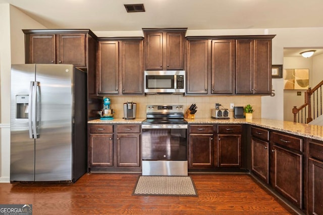 106 Cessna Dr, Canton, GA 30114 - kitchen featuring appliances with stainless steel finishes, light stone counters, decorative backsplash, and dark brown cabinetry