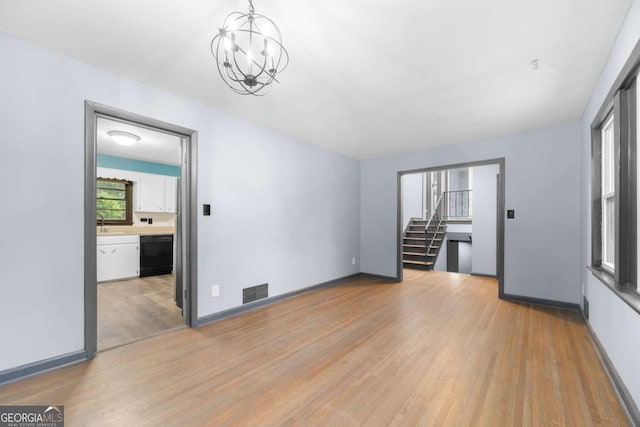 3664 Pin Oak Cir, Atlanta, GA 30340 - spare room featuring light wood finished floors, a chandelier, and stairway