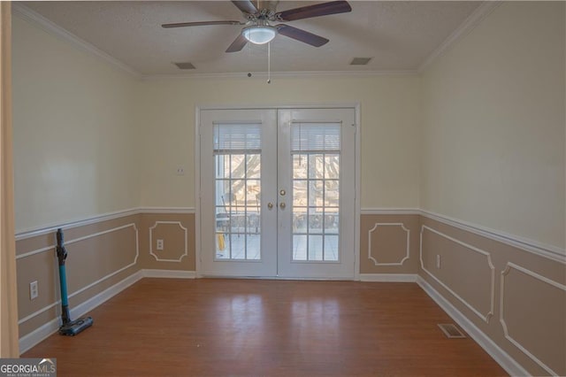 726 Mcdaniel Mill Rd SW, Conyers, GA 30094 - empty room with french doors, wood finished floors, a ceiling fan, wainscoting, and a textured ceiling