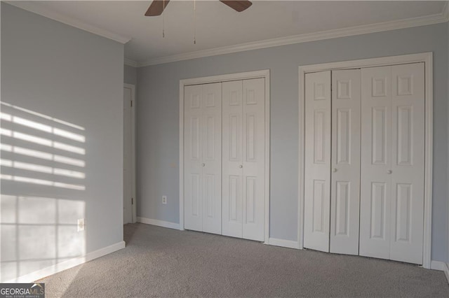 726 Mcdaniel Mill Rd SW, Conyers, GA 30094 - unfurnished bedroom featuring carpet, multiple closets, ornamental molding, baseboards, and ceiling fan