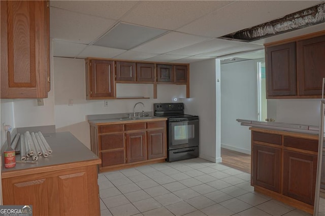 726 Mcdaniel Mill Rd SW, Conyers, GA 30094 - kitchen featuring black / electric stove, a sink, light tile patterned floors, a paneled ceiling, and brown cabinets