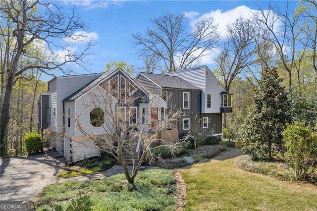 10845 Shallowford Rd, Roswell, GA 30075 - view of front of house featuring driveway, a front lawn, and board and batten siding