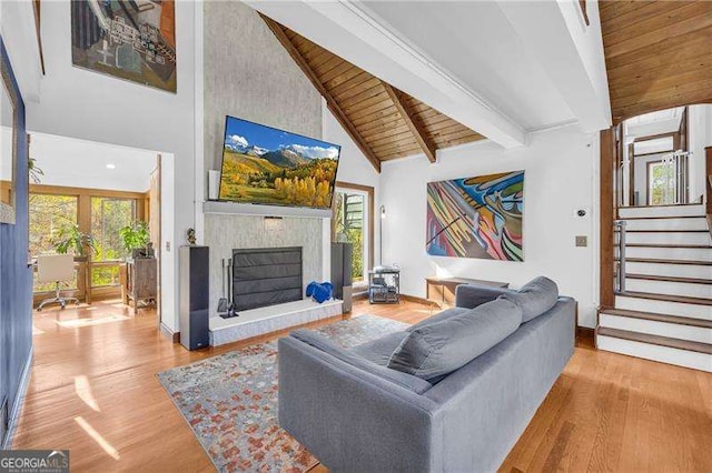 10845 Shallowford Rd, Roswell, GA 30075 - living room featuring a wood ceiling with exposed beams, a fireplace with raised hearth, high vaulted ceiling, wood finished floors, and stairway