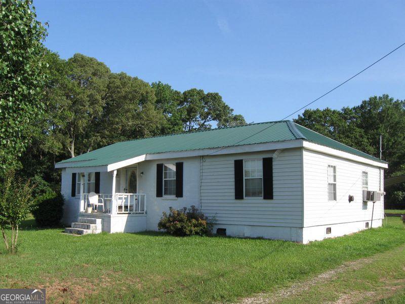 581 Hudson Rd, Griffin, GA 30224 - view of front of home featuring a porch, a front yard, metal roof, and crawl space