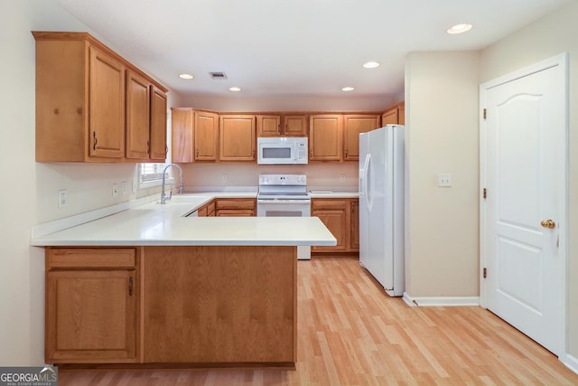 101 Coldbrook Cir, Rincon, GA 31326 - kitchen featuring white appliances, a peninsula, light countertops, light wood-style floors, and recessed lighting