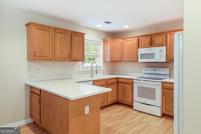 101 Coldbrook Cir, Rincon, GA 31326 - kitchen with white appliances, a peninsula, light wood-type flooring, recessed lighting, and light countertops