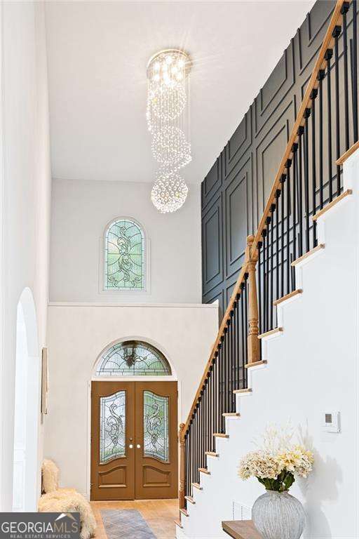5705 Registry Oaks Ln SE, Mableton, GA 30126 - entrance foyer with a towering ceiling, a chandelier, stairs, and french doors
