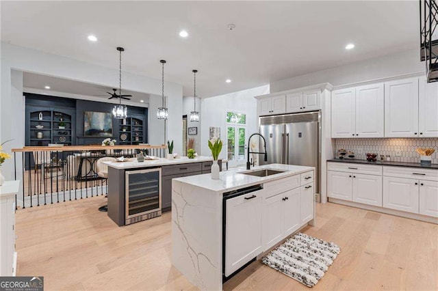5705 Registry Oaks Ln SE, Mableton, GA 30126 - kitchen featuring wine cooler, dishwashing machine, a sink, an island with sink, and light wood finished floors