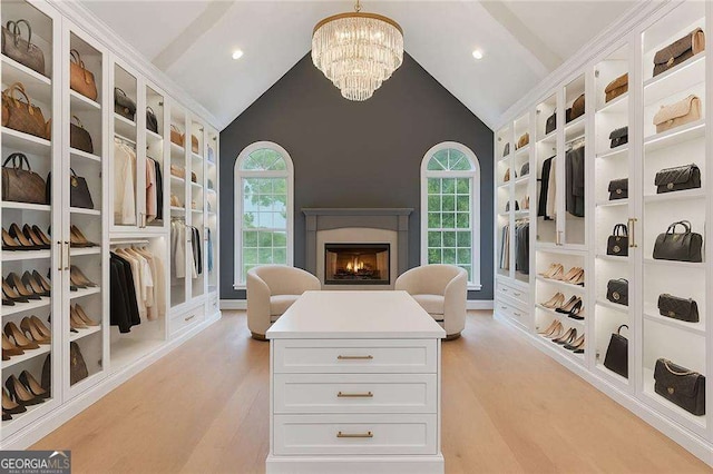 5705 Registry Oaks Ln SE, Mableton, GA 30126 - walk in closet featuring a chandelier, light wood finished floors, a lit fireplace, and high vaulted ceiling
