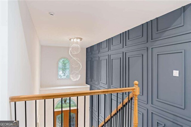 5705 Registry Oaks Ln SE, Mableton, GA 30126 - hallway featuring a chandelier, a decorative wall, and an upstairs landing