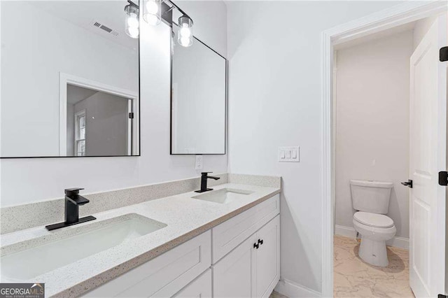 5705 Registry Oaks Ln SE, Mableton, GA 30126 - bathroom featuring marble finish floors, double vanity, toilet, and baseboards