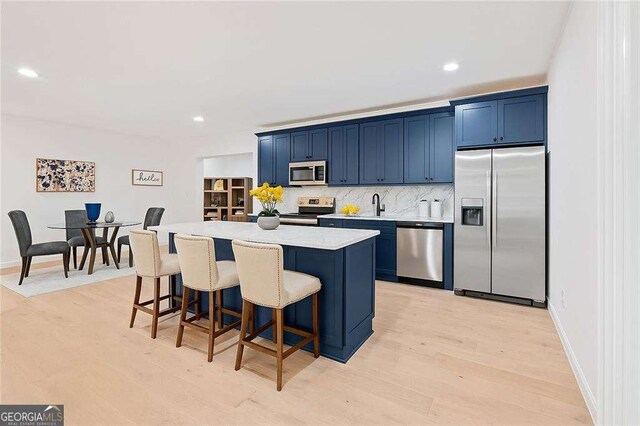 5705 Registry Oaks Ln SE, Mableton, GA 30126 - kitchen with stainless steel appliances, blue cabinetry, a kitchen bar, a center island, and recessed lighting