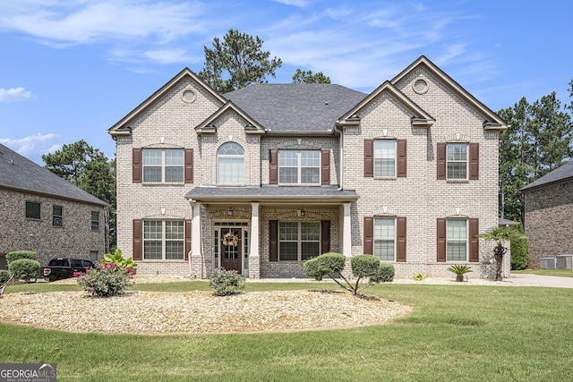 6861 Louis Dr, Locust Grove, GA 30248 - view of front of home featuring brick siding, a front lawn, covered porch, and roof with shingles