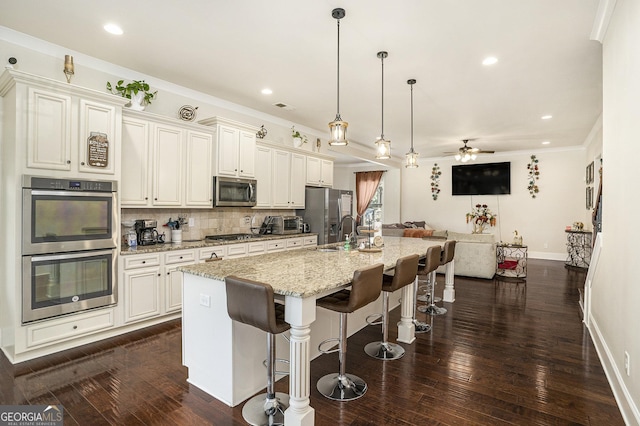 6861 Louis Dr, Locust Grove, GA 30248 - kitchen featuring appliances with stainless steel finishes, baseboards, a kitchen island with sink, tasteful backsplash, and a breakfast bar area