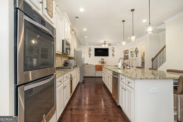 6861 Louis Dr, Locust Grove, GA 30248 - kitchen featuring appliances with stainless steel finishes, a sink, ornamental molding, a breakfast bar, and a ceiling fan