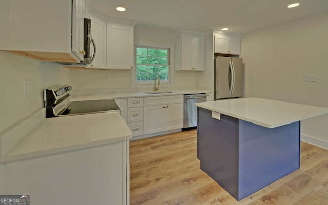 340 Currahee Trl, Toccoa, GA 30577 - kitchen with stainless steel appliances, a sink, white cabinetry, light countertops, and light wood-style floors