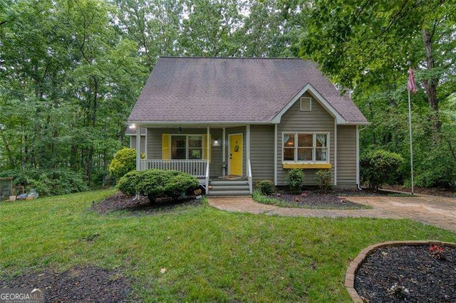 34 Sassafras Grv, Dawsonville, GA 30534 - view of front facade with covered porch, a front yard, and roof with shingles