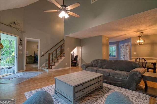34 Sassafras Grv, Dawsonville, GA 30534 - living area with healthy amount of natural light, stairway, wood finished floors, baseboards, and high vaulted ceiling