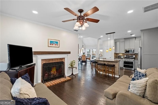 10735 Pinewalk Forest Cir, Alpharetta, GA 30022 - living area with ceiling fan, crown molding, recessed lighting, dark wood finished floors, and a fireplace