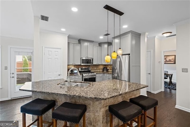 10735 Pinewalk Forest Cir, Alpharetta, GA 30022 - kitchen with stainless steel appliances, gray cabinetry, a sink, backsplash, and dark wood finished floors