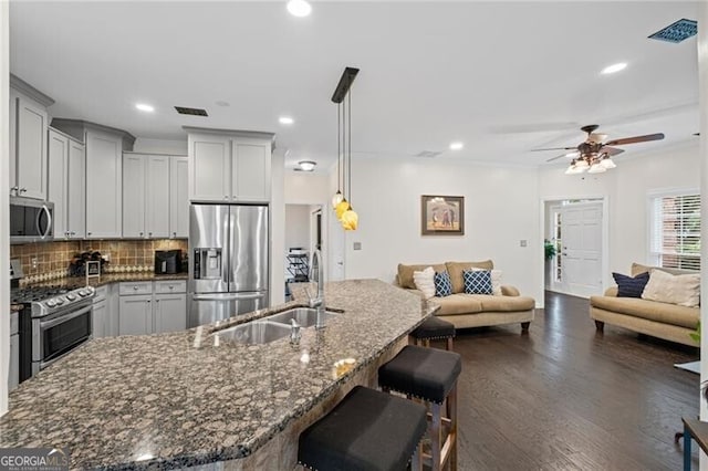 10735 Pinewalk Forest Cir, Alpharetta, GA 30022 - kitchen featuring appliances with stainless steel finishes, a sink, open floor plan, ceiling fan, and a breakfast bar