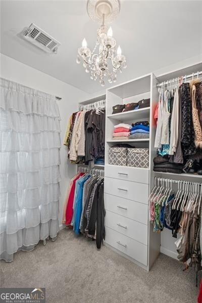 10735 Pinewalk Forest Cir, Alpharetta, GA 30022 - walk in closet with carpet flooring and a chandelier