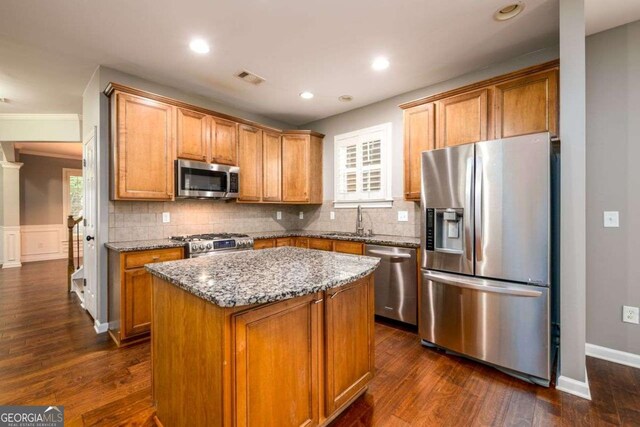 4916 Gathering Pl, Suwanee, GA 30024 - kitchen featuring stainless steel appliances, stone counters, backsplash, dark wood-style flooring, and a kitchen island