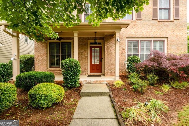 4916 Gathering Pl, Suwanee, GA 30024 - doorway to property featuring a porch and brick siding