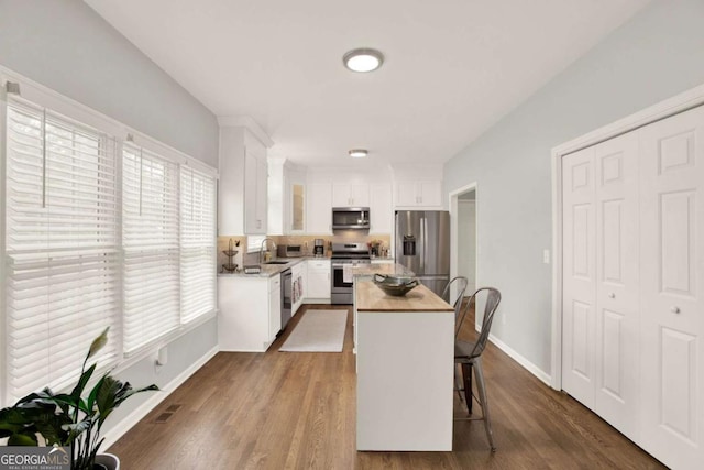224 Mountain View Dr, Woodstock, GA 30188 - kitchen with appliances with stainless steel finishes, a sink, a center island, white cabinets, and baseboards