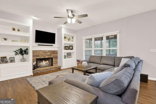 224 Mountain View Dr, Woodstock, GA 30188 - living room with ceiling fan, wood finished floors, built in shelves, and a stone fireplace